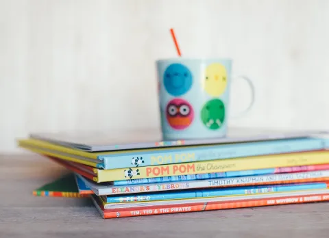 A stack of books with a mug on top