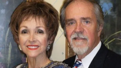 Edi Minelli and Richard Shaffer of Just Us Duo smiling and dressed in formal attire, standing close together.